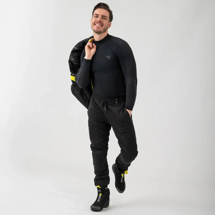Man klädd i Shima Kevlar Mc-Byxor Joggster Svart, kombinerat med motorcykeljacka och stövlar för en komplett look.